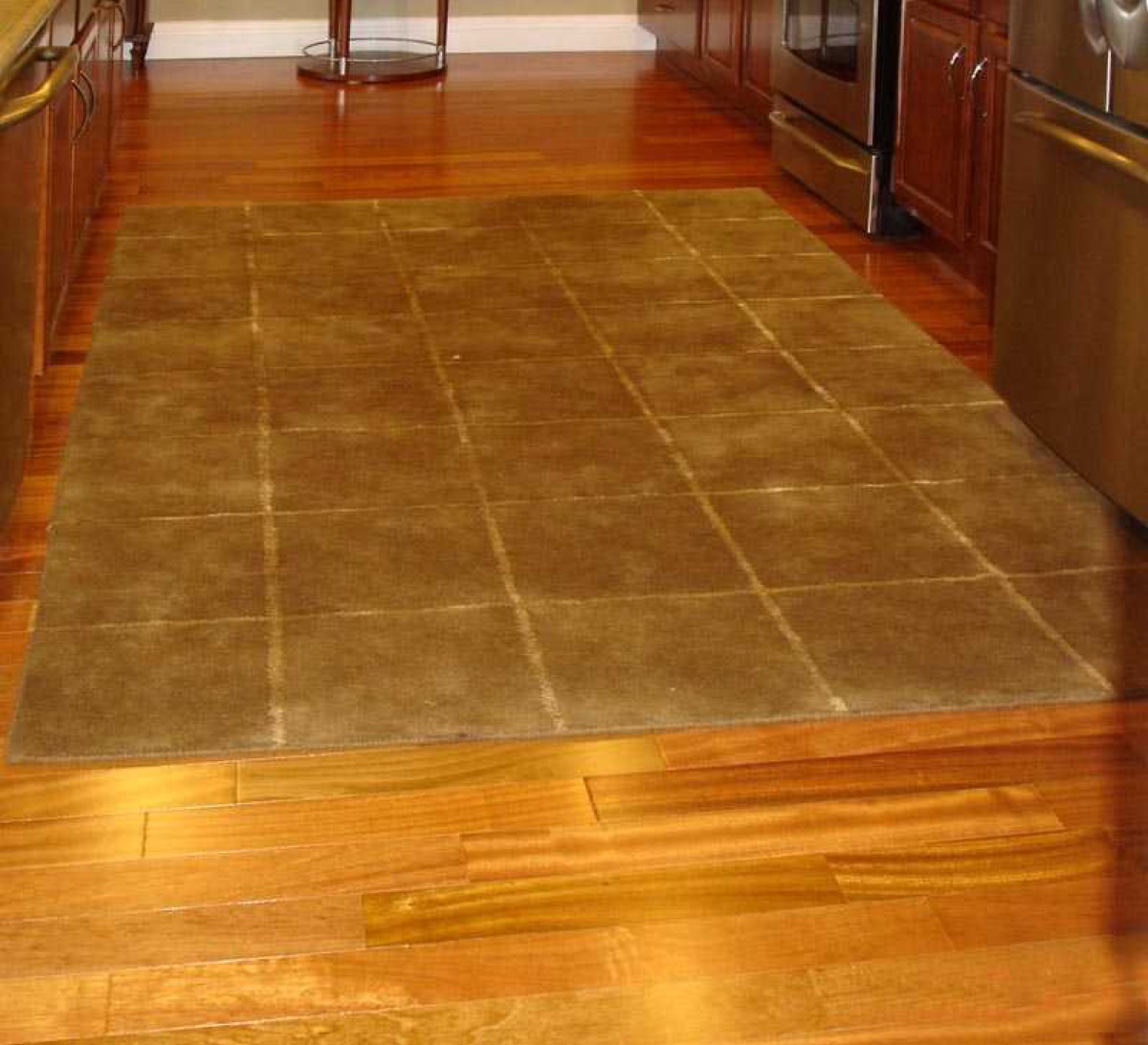 Reddish cherry hardwood in a kitchen with area rug