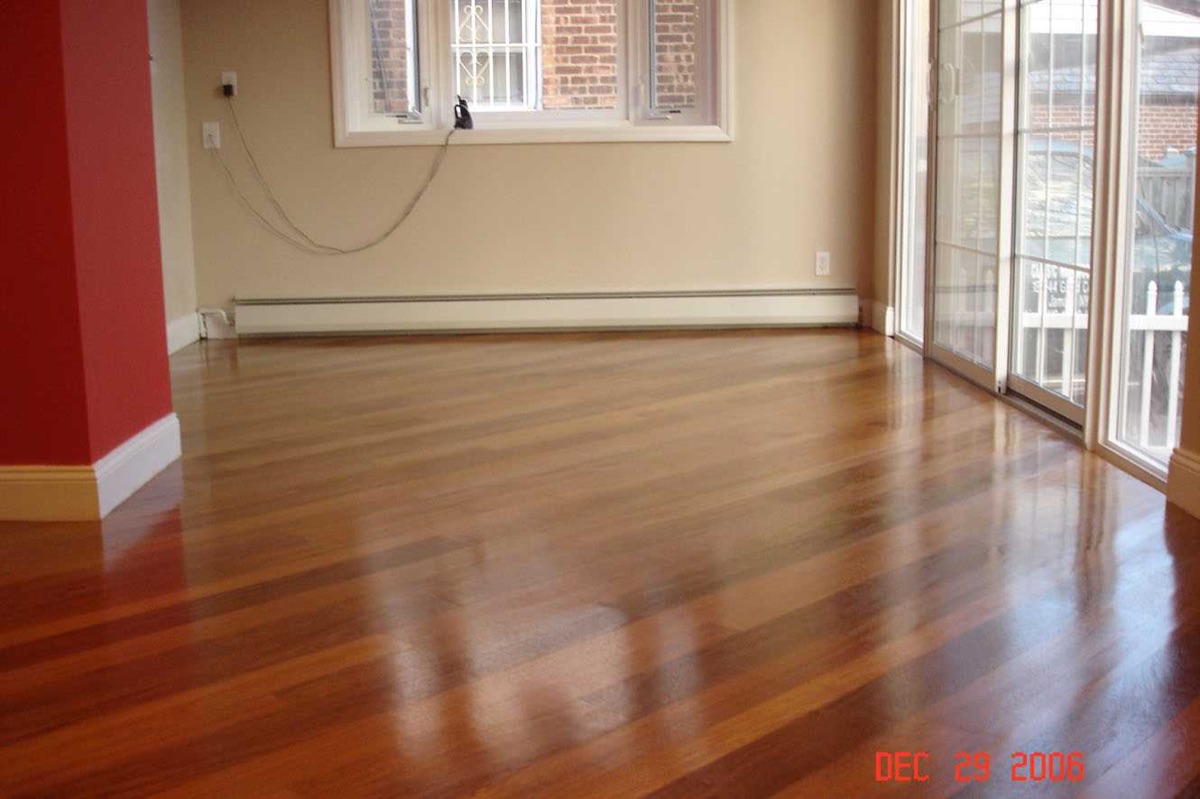 Glossy cherry strip floor in an empty living room after refinish